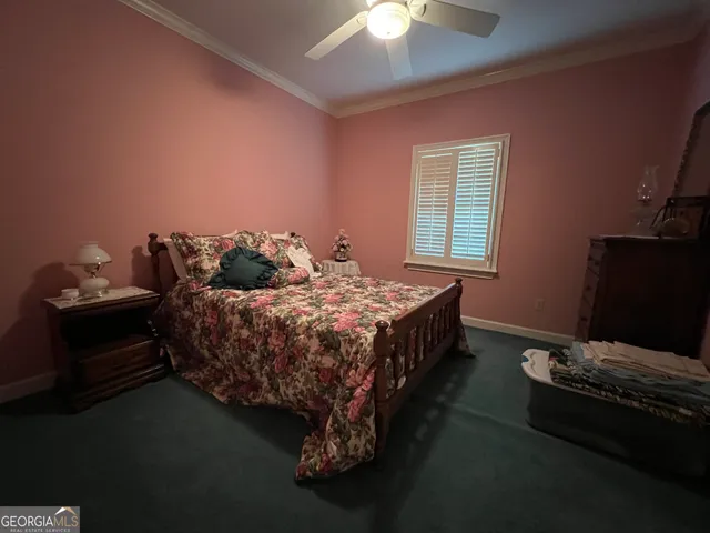 a bedroom with a bed and a dresser next to a window