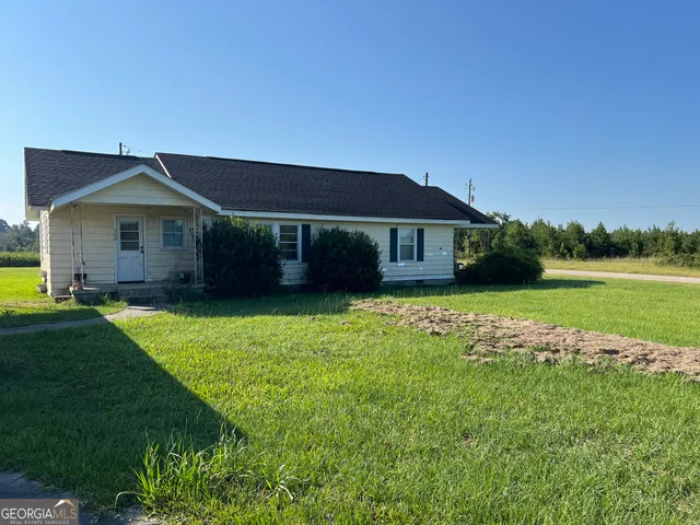 a view of house with yard and sitting area