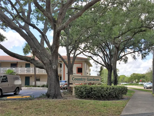 a front view of a house with garden and trees