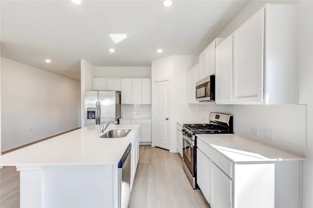 a kitchen that has a sink a stove and a refrigerator