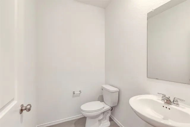 a white toilet sitting next to a white sink