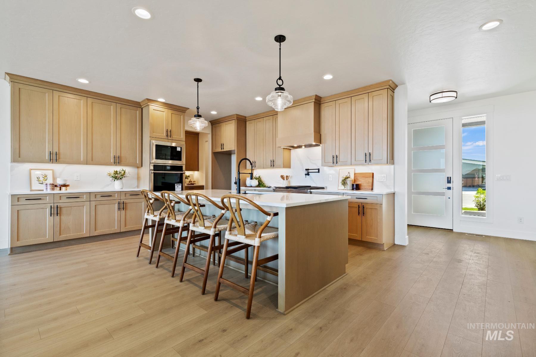 8650 West Inspirado Street Meridian, ID 83646 - Photo 15 of 30 Kitchen featuring light brown cabinetry, hanging light fixtures, stainless steel appliances, and recessed lighting