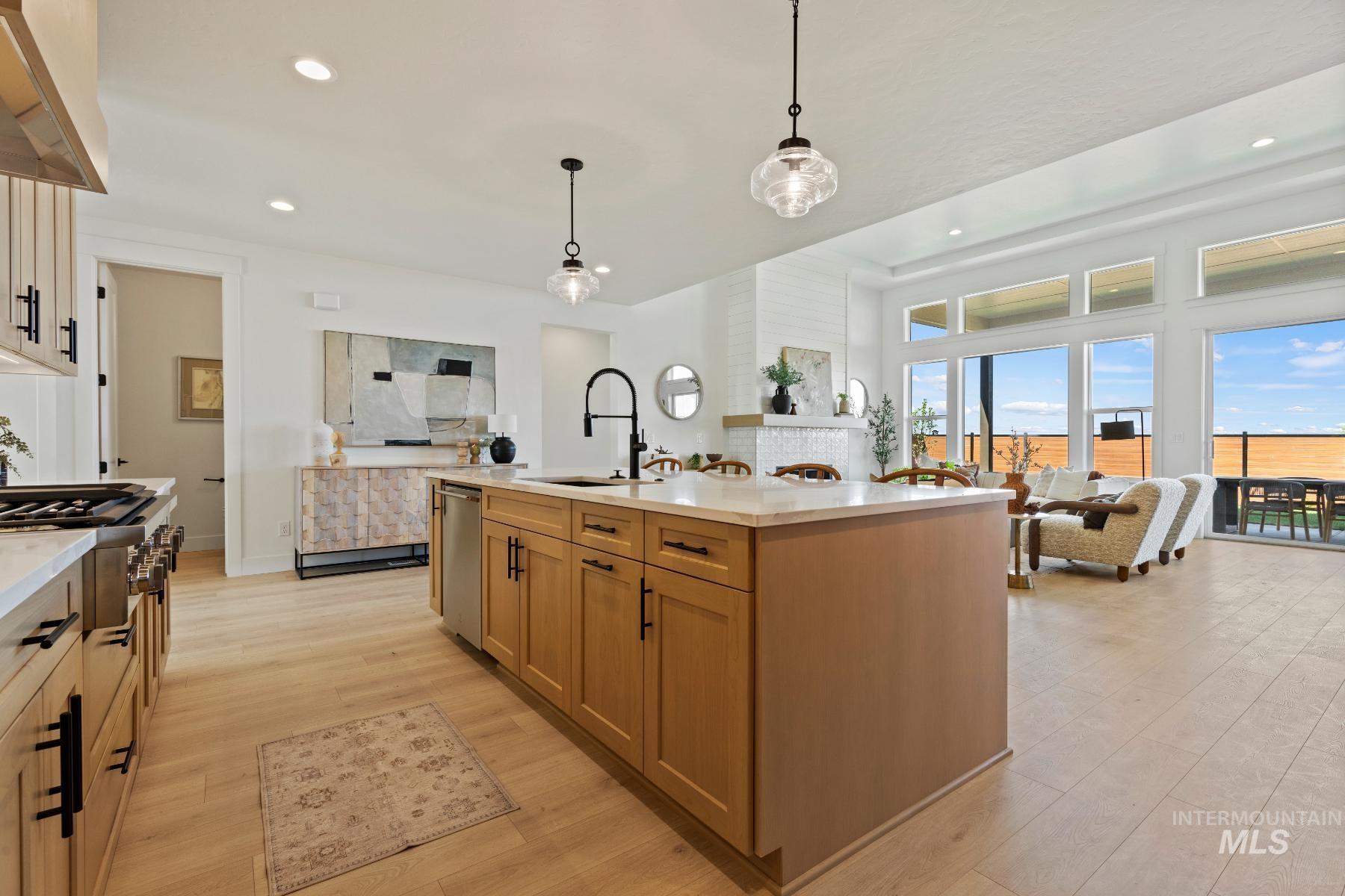 8650 West Inspirado Street Meridian, ID 83646 - Photo 30 of 30 Kitchen with open floor plan, pendant lighting, recessed lighting, light wood finished floors, and brown cabinetry