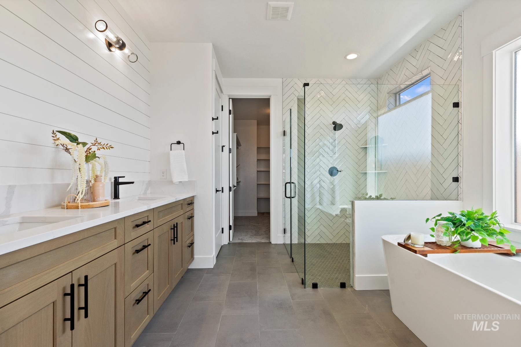 8650 West Inspirado Street Meridian, ID 83646 - Photo 26 of 30 Bathroom with double vanity, a freestanding bath, a shower stall, and a walk in closet
