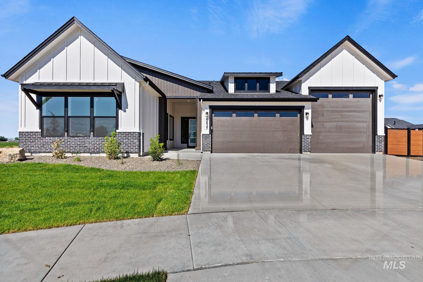 8650 West Inspirado Street Meridian, ID 83646 - Photo 3 of 30 Modern farmhouse style home with board and batten siding, a garage, driveway, and brick siding