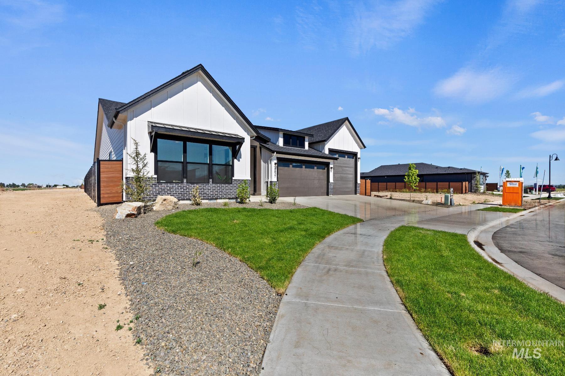 8650 West Inspirado Street Meridian, ID 83646 - Photo 5 of 30 Modern farmhouse featuring board and batten siding, a front lawn, concrete driveway, and brick siding