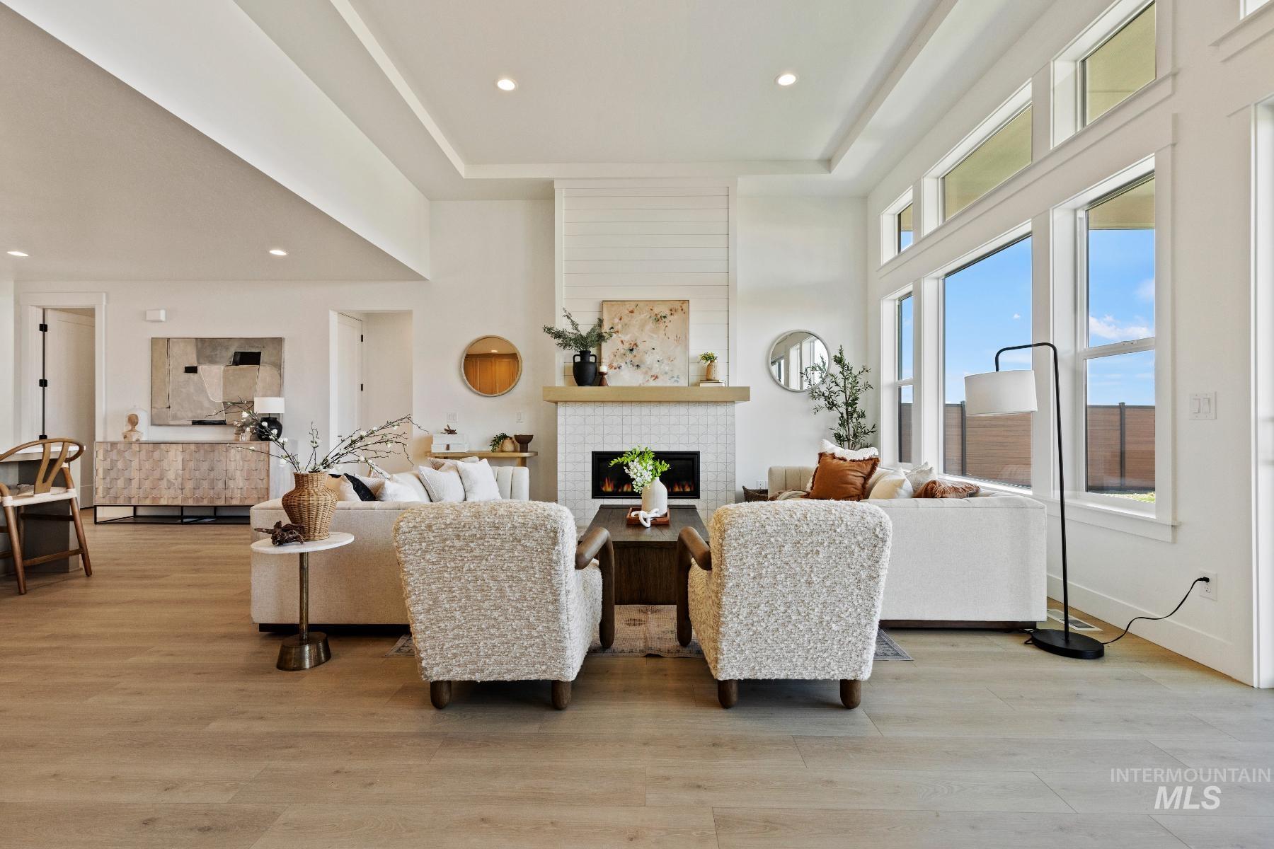 8650 West Inspirado Street Meridian, ID 83646 - Photo 8 of 30 Living room with a tile fireplace, light wood-style flooring, a towering ceiling, and recessed lighting