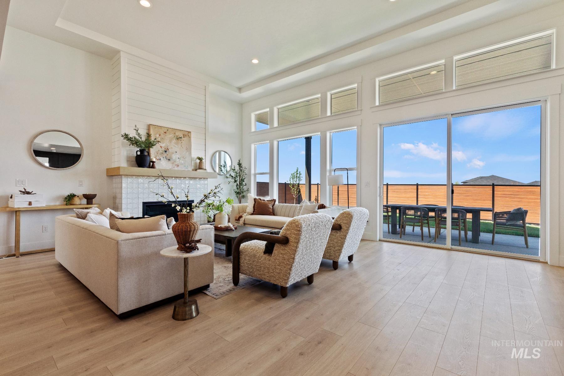 8650 West Inspirado Street Meridian, ID 83646 - Photo 9 of 30 Living area with a towering ceiling, a large fireplace, light wood finished floors, and recessed lighting