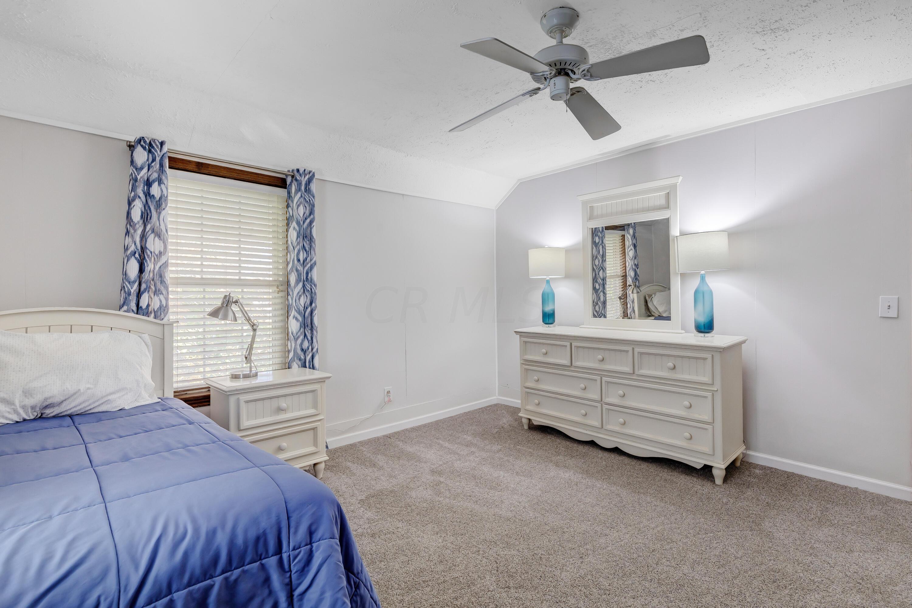 6681 Harlem Road Westerville, OH 43082 - Photo 32 of 78 • New tan carpet ~ 2022 • Light grey painted walls • Ceiling fan • Closet with double sliding doors • 2” blinds remain • Drapes remain