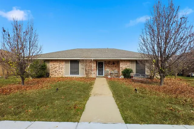 a front view of house with yard slide and trees