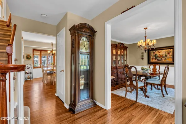 a view of a dining room and livingroom with furniture wooden floor a chandelier
