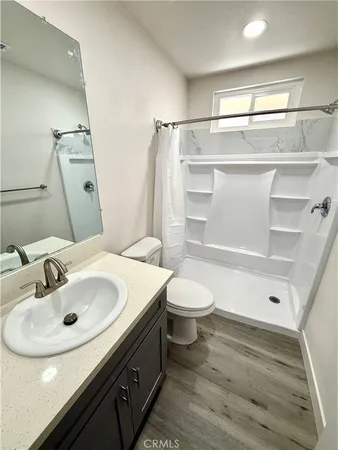 a bathroom with a sink a toilet and shower