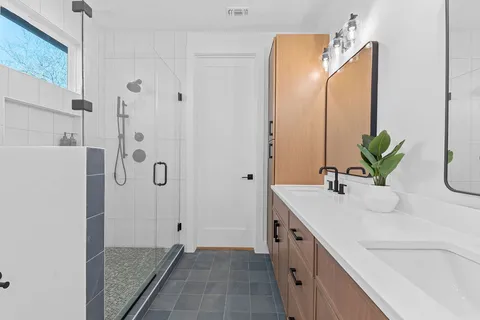 a bathroom with a double vanity sink and a mirror
