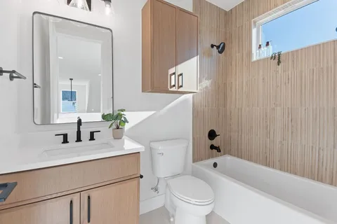 a bathroom with a sink a toilet and shower