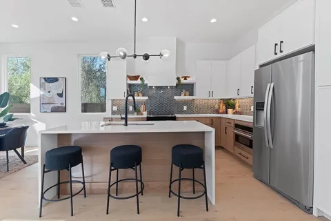 a kitchen with refrigerator cabinets and chairs