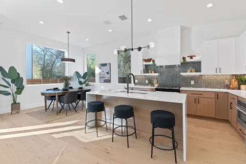 a large kitchen with kitchen island a dining table and chairs