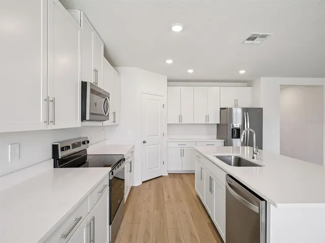 a kitchen with white cabinets sink and stainless steel appliances