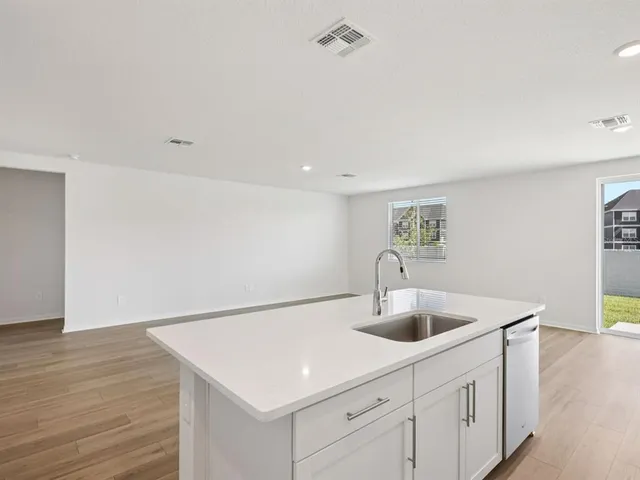 a kitchen with a sink cabinets and wooden floor