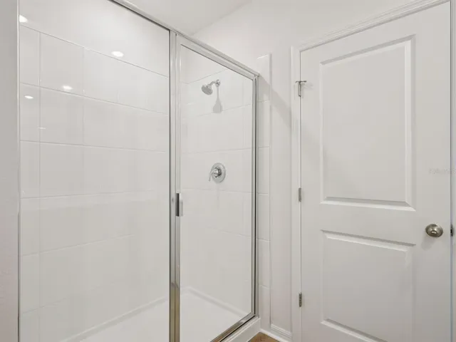 a bathroom with a shower and a glass door