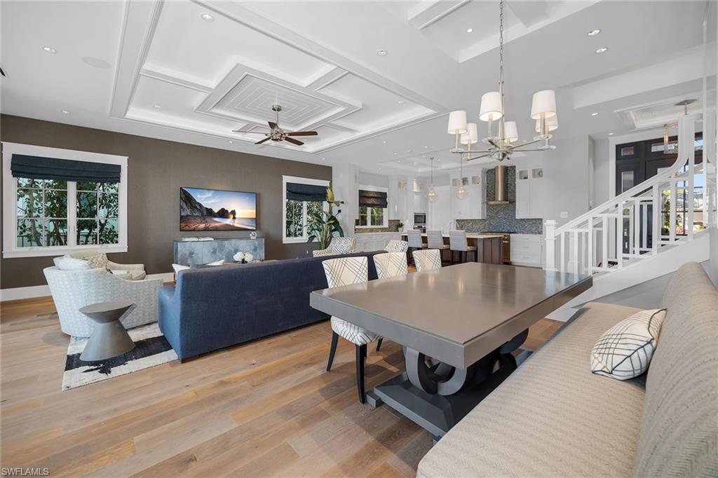 185 15th Street South Naples, FL 34102 - Photo 11 of 49 a living room with furniture a dining table and a chandelier