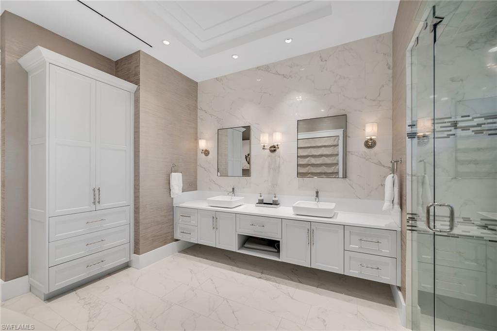 185 15th Street South Naples, FL 34102 - Photo 15 of 49 a spacious bathroom with a double vanity sink a mirror and a bathtub