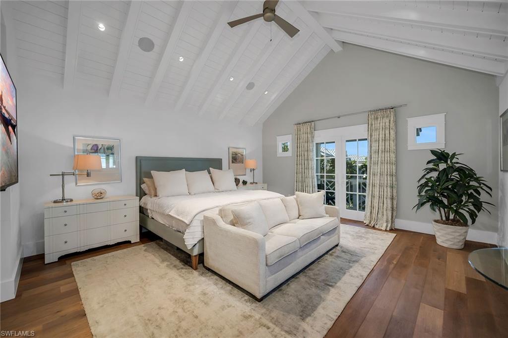 185 15th Street South Naples, FL 34102 - Photo 18 of 49 a spacious bedroom with a large bed and a potted plant
