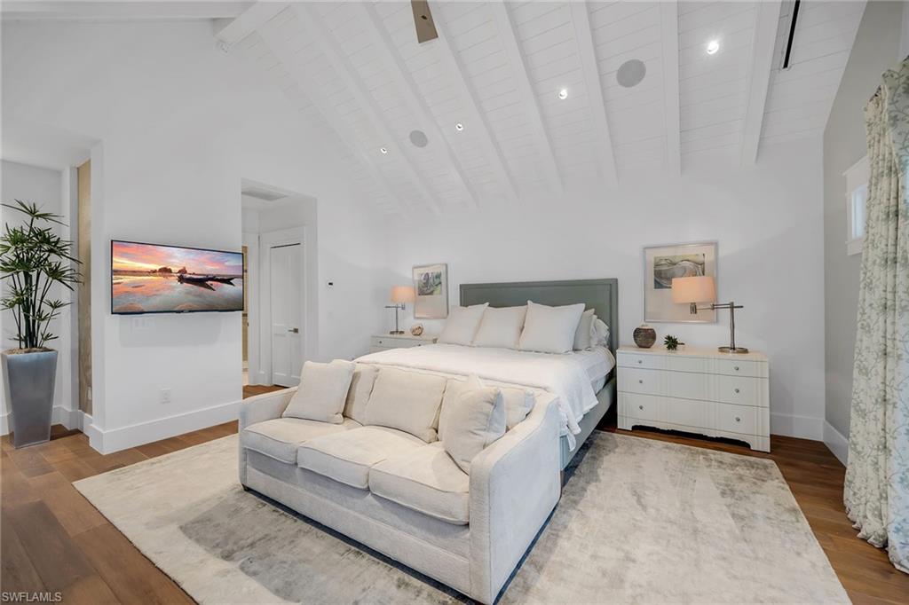 185 15th Street South Naples, FL 34102 - Photo 19 of 49 a spacious bedroom with a bed and a couch