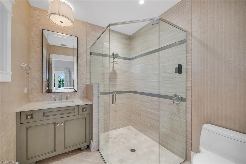 185 15th Street South Naples, FL 34102 - Photo 23 of 49 a bathroom with a shower sink and mirror