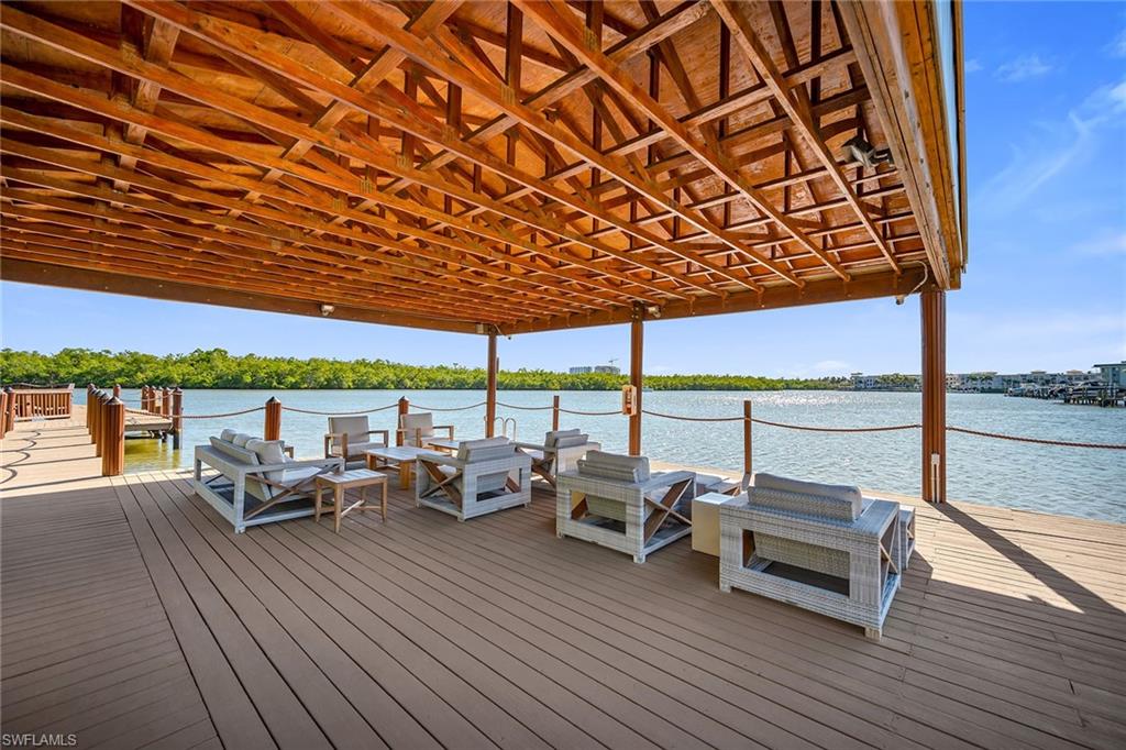 185 15th Street South Naples, FL 34102 - Photo 45 of 49 a roof deck with table and chairs under an umbrella with wooden floor
