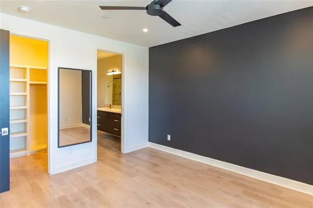 an empty room with closet and a chandelier fan
