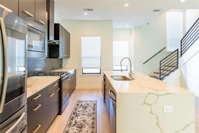 a large kitchen with kitchen island a sink stainless steel appliances and cabinets