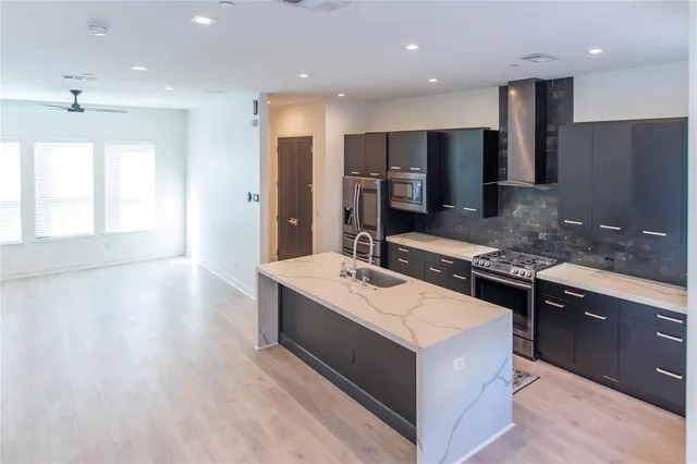 a kitchen with stainless steel appliances granite countertop a sink stove and refrigerator