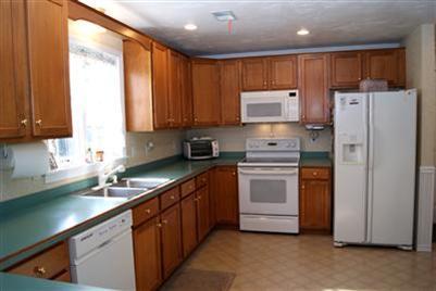 124 Captain Samadrus Road Cotuit, MA 02635 - Photo 3 of 18 a kitchen with stainless steel appliances a refrigerator sink and cabinets