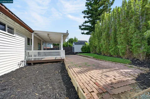a porch with a bench next to yard