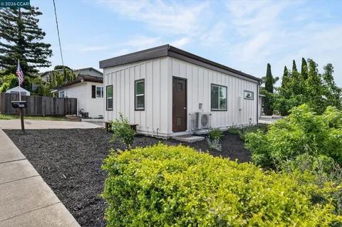 a view of a house with backyard and sitting area