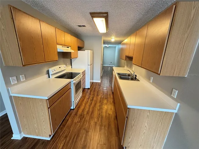 a kitchen that has a sink and a wooden floor