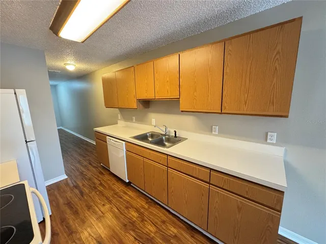 a kitchen with sink cabinets and wooden floor