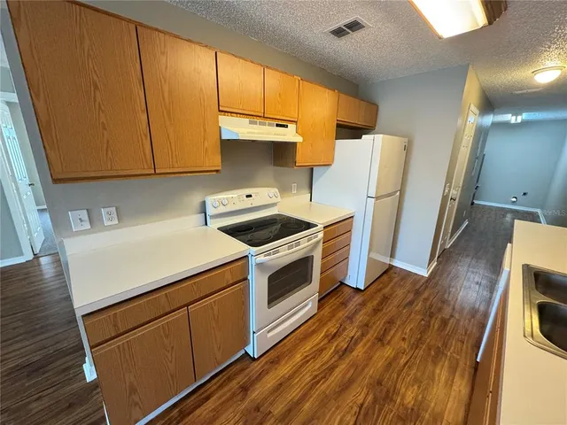 a kitchen with a white stove top oven sink and cabinets