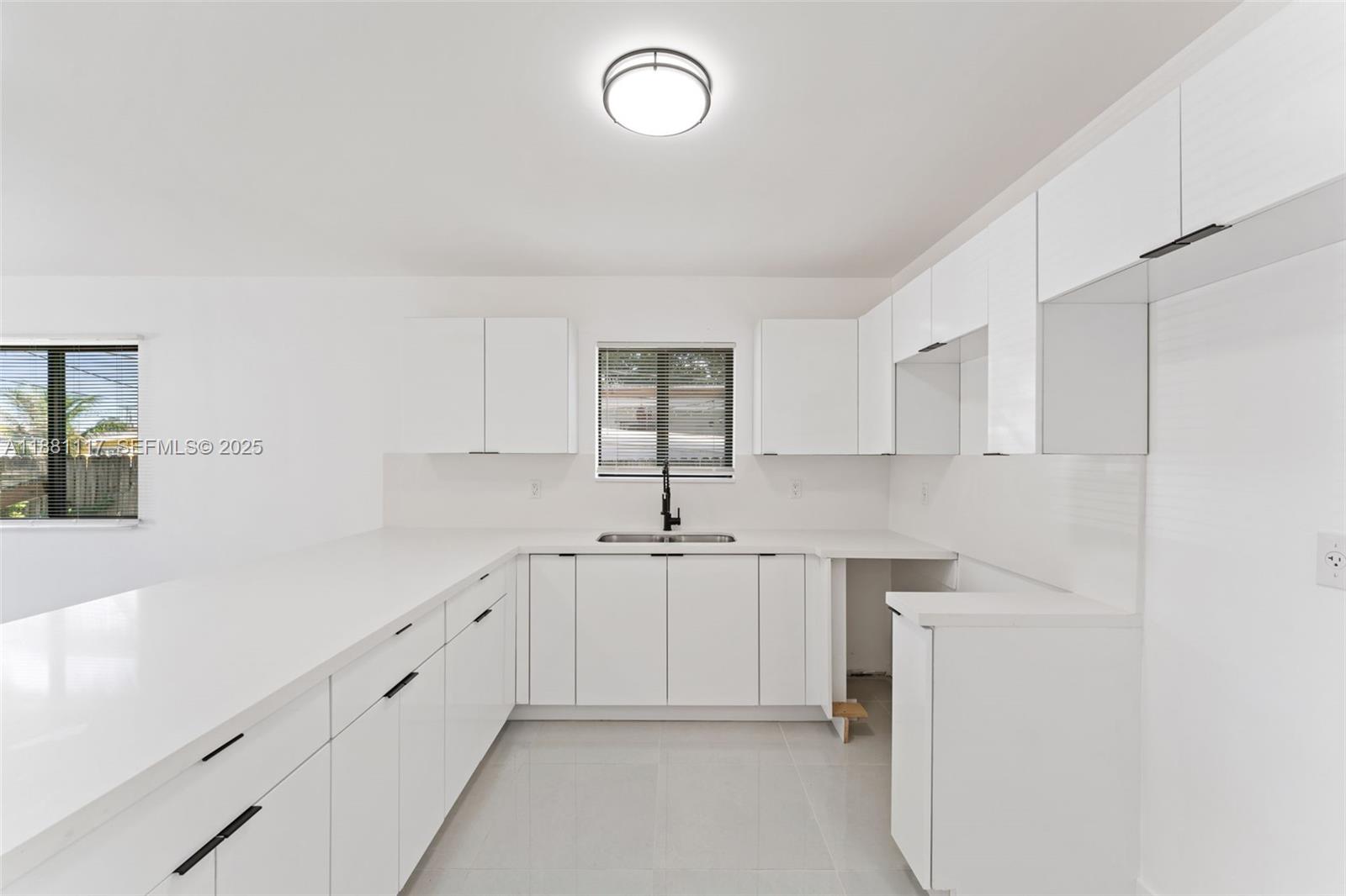 1556 Northwest 68th Terrace Miami, FL 33147 - Photo 7 of 14 a kitchen with white cabinets and sink