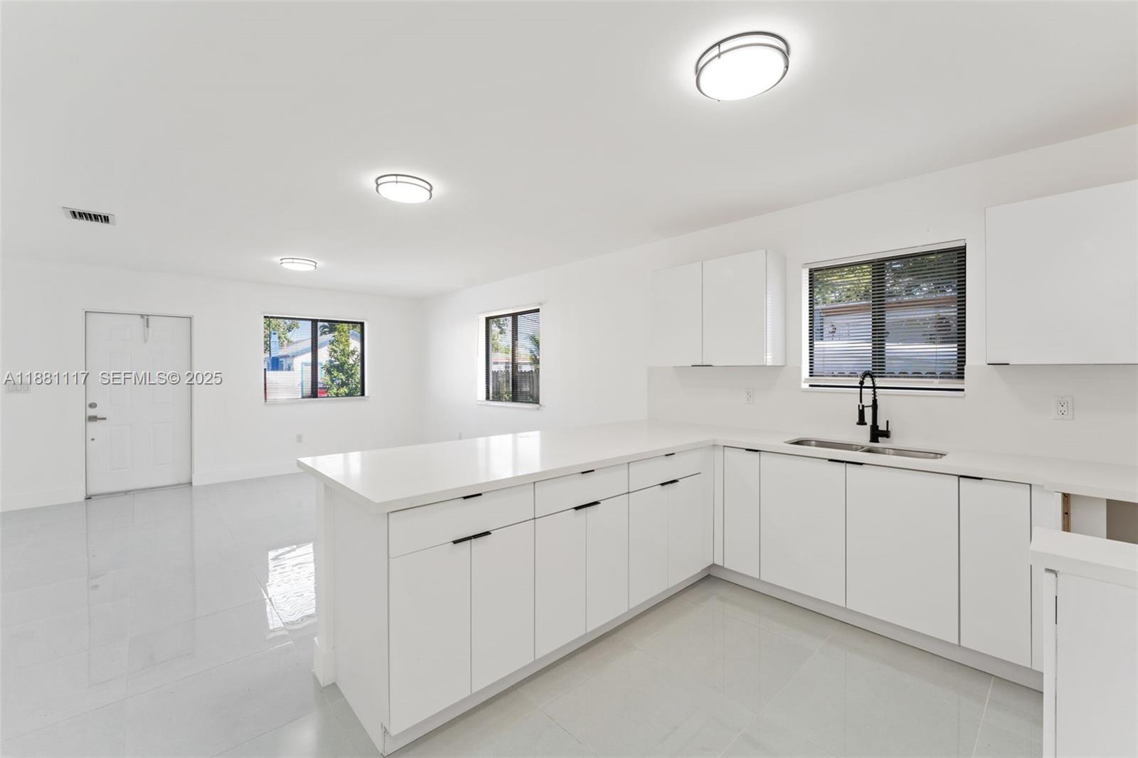 1556 Northwest 68th Terrace Miami, FL 33147 - Photo 8 of 14 a kitchen with sink and mirror