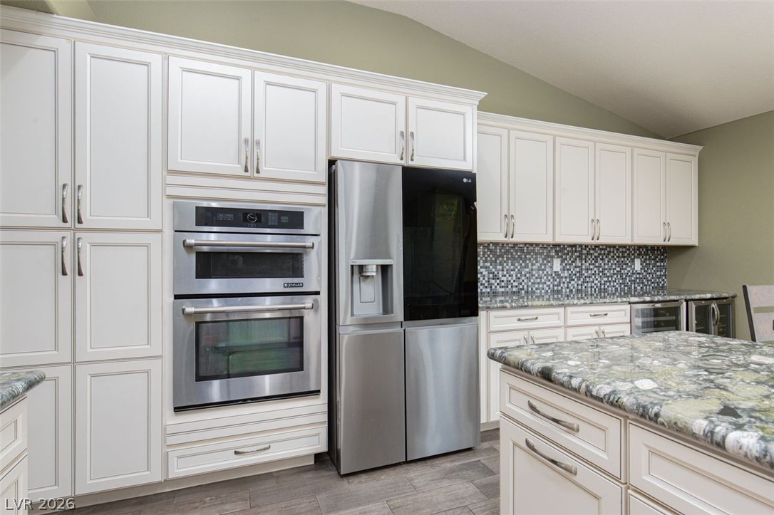 4670 Los Rancheros Avenue Las Vegas, NV 89129 - Photo 18 of 57 Granite countertops and customized cabinetry define this modern kitchen space.
