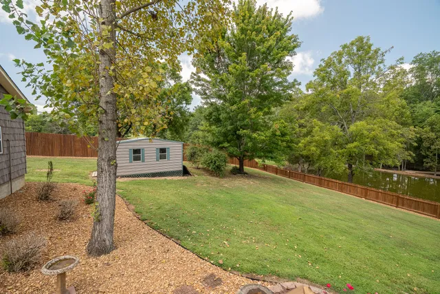 a front view of a house with a yard and tree