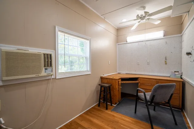 a view of kitchen and empty room with wooden floor