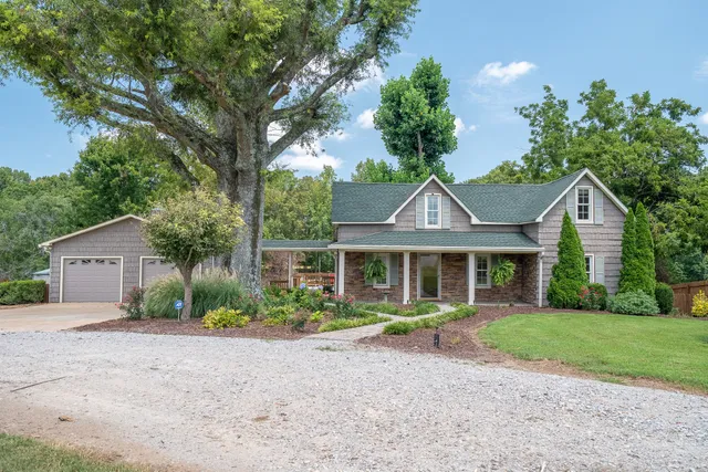 a front view of a house with a yard and potted plants