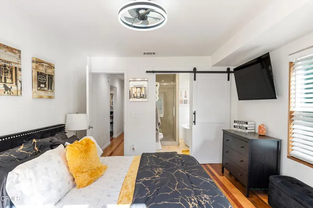 a bedroom with a bed and a flat screen tv