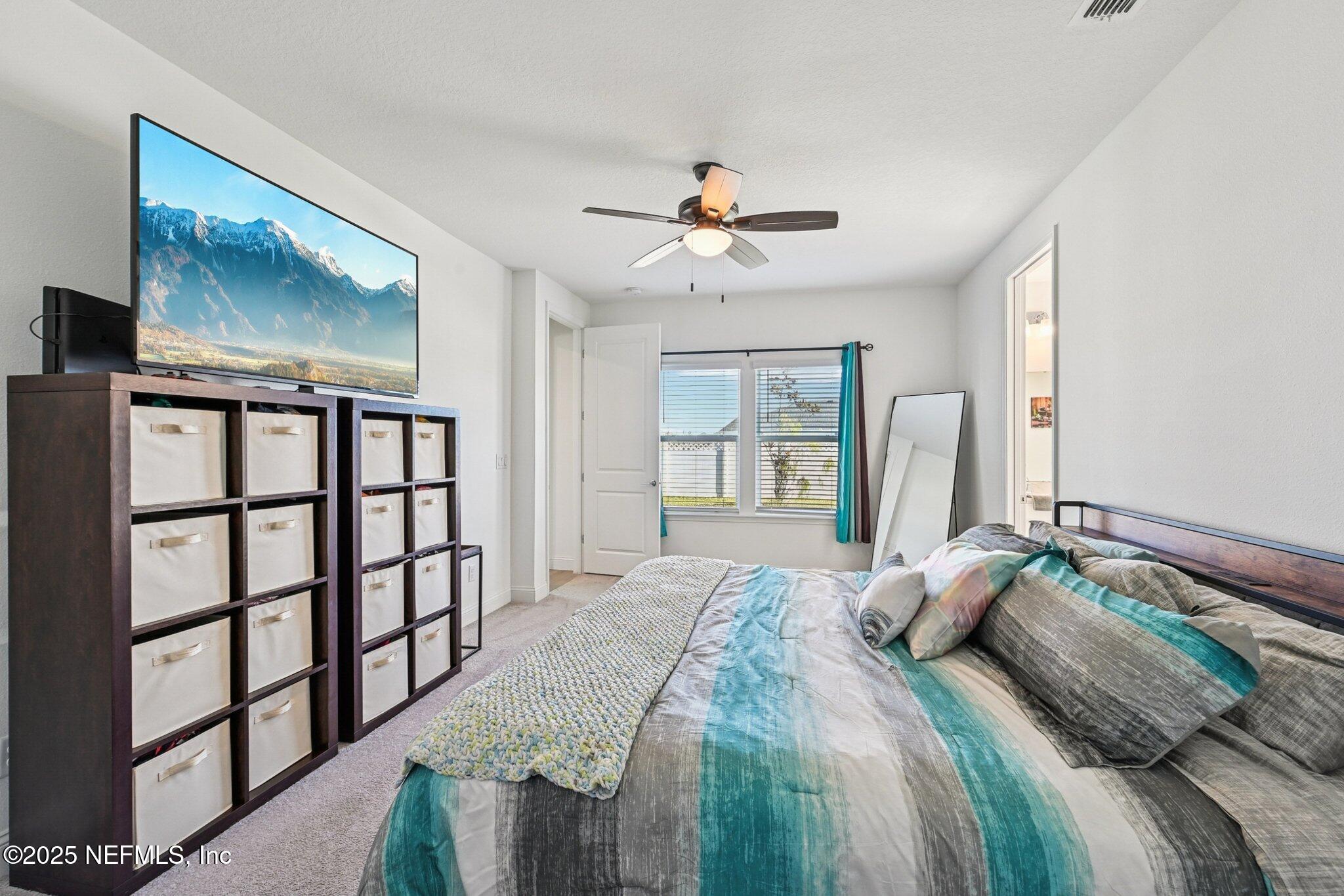 181 Varner Way St. Augustine, FL 32092 - Photo 20 of 27 a bedroom with a large bed and a chandelier