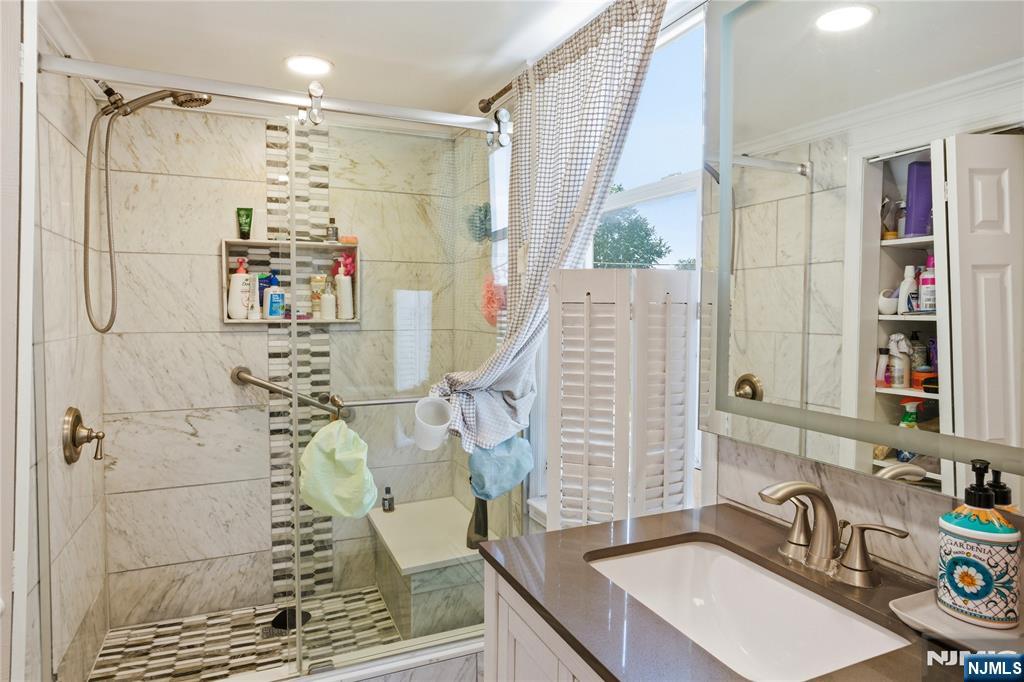 33-35 Pulaski Place Hackensack, NJ 07601 - Photo 14 of 32 a bathroom with a sink and a mirror