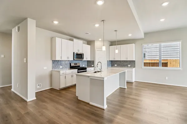 a kitchen with cabinets wooden floor and a sink