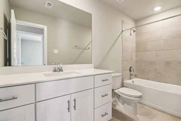 a bathroom with a granite countertop toilet sink and mirror
