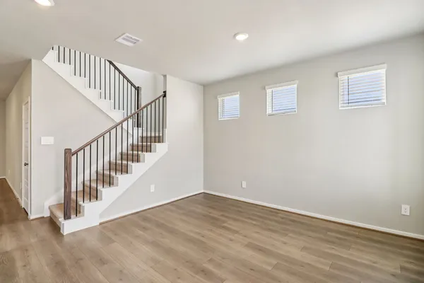 a view of staircase with wooden floor and white walls